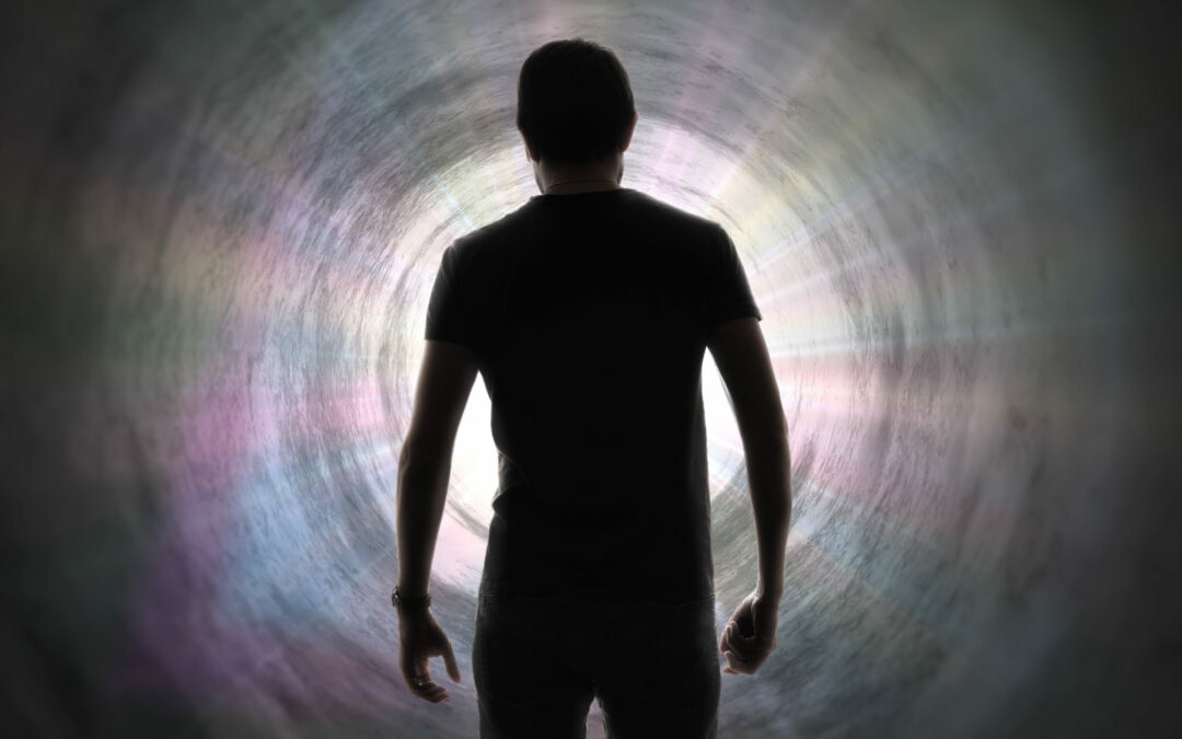 Silhouette of man’s soul is going to bright light – rays of god inside tunnel. Life after death concept.