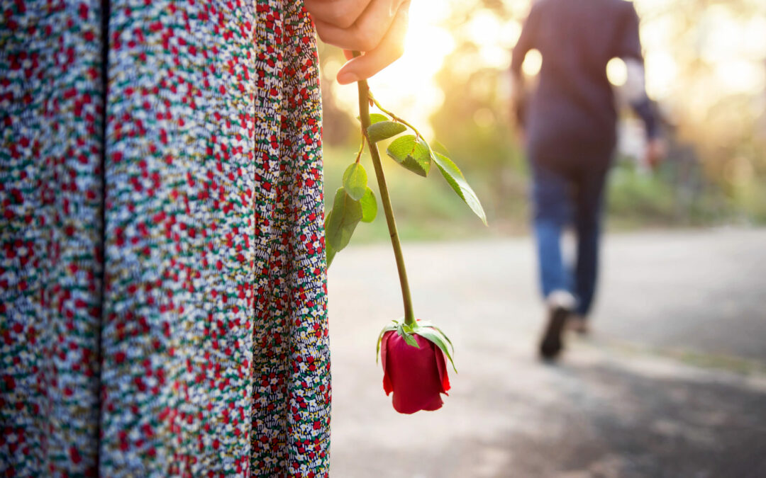 Sadness Love in Ending of Relationship Concept, Broken Heart Woman Standing with a Red Rose on Hand, Blurred Man in Back Side Walking away as background