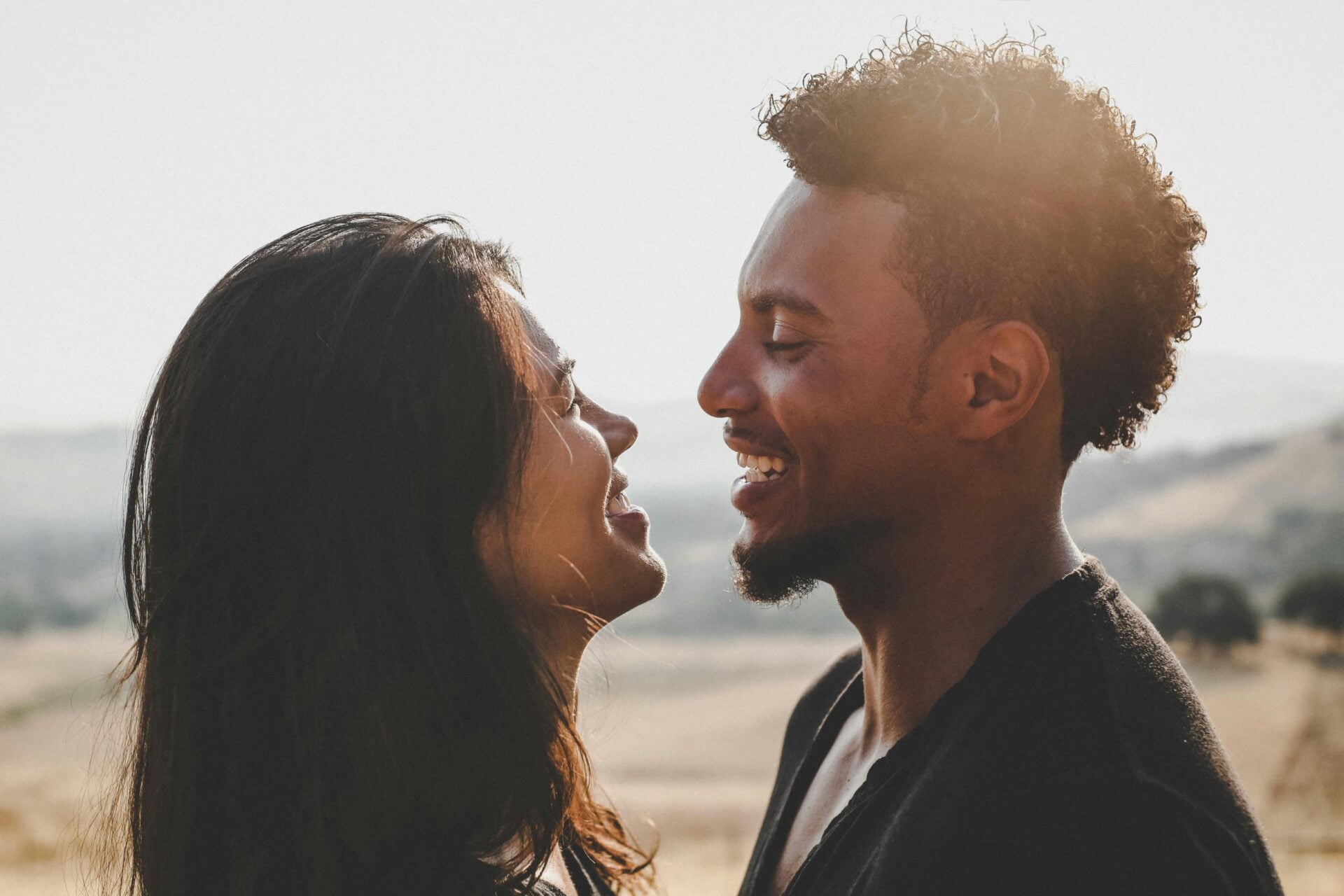 A man and a woman smiling at each other outdoors